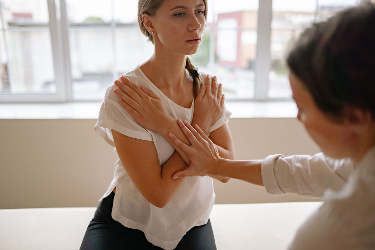 A seated chiropractic adjustment, the patient's arms crossed